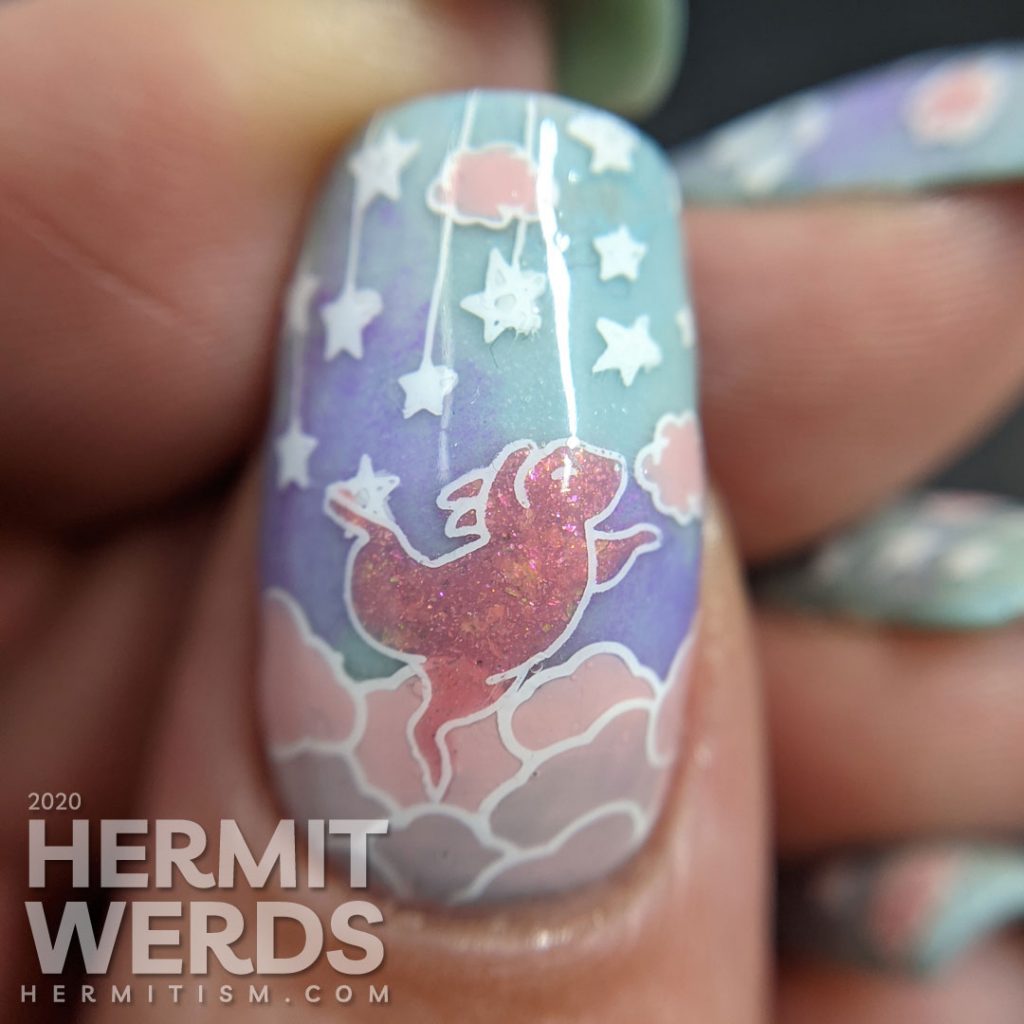 A soft blue, purple, and pink nail art of cute bunnies living in the clouds with an aqua glow in the dark special effect.