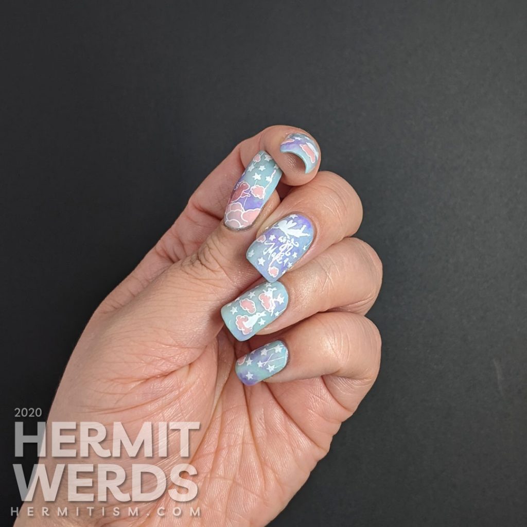 A soft blue, purple, and pink nail art of cute bunnies living in the clouds with an aqua glow in the dark special effect.