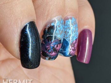 Purple and blue rose-themed nail art with layered stamping roses on a matte blue glitter background.