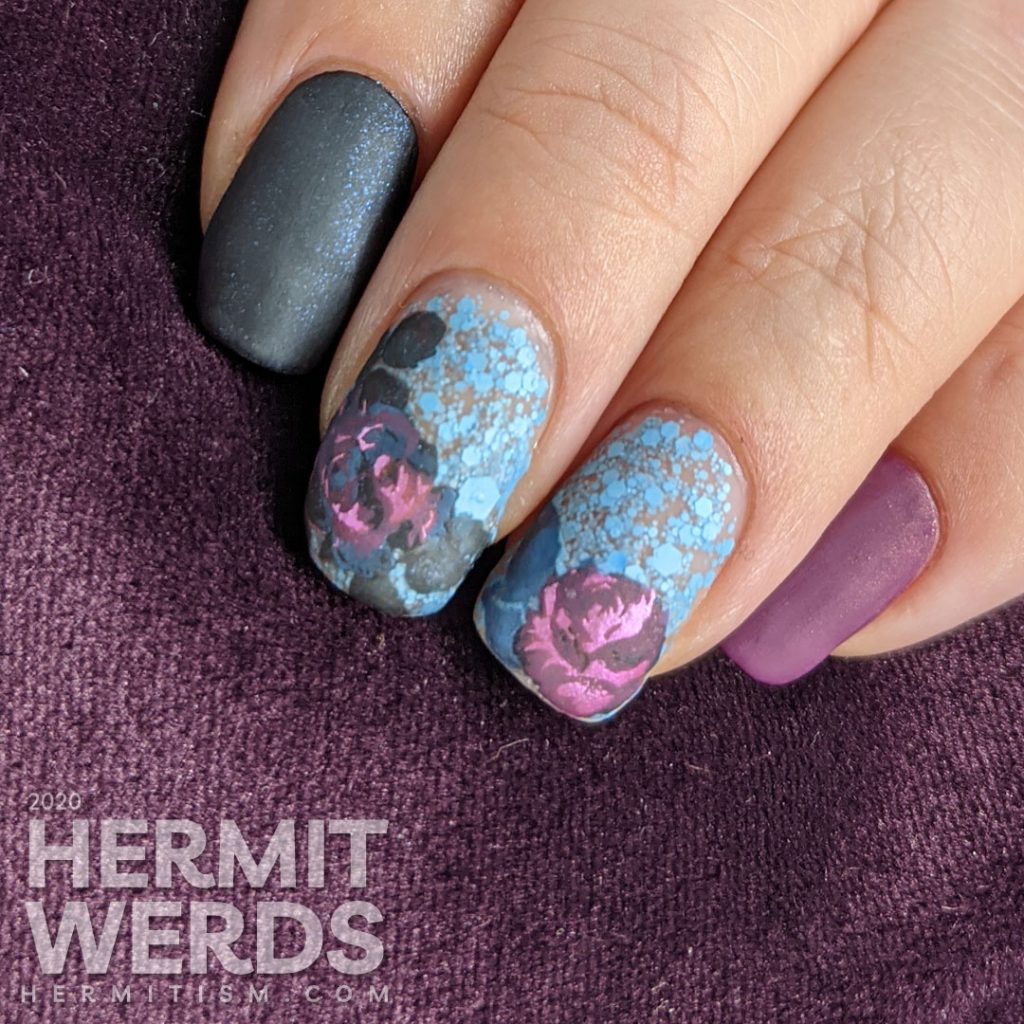 Purple and blue rose-themed nail art with layered stamping roses on a matte blue glitter background.