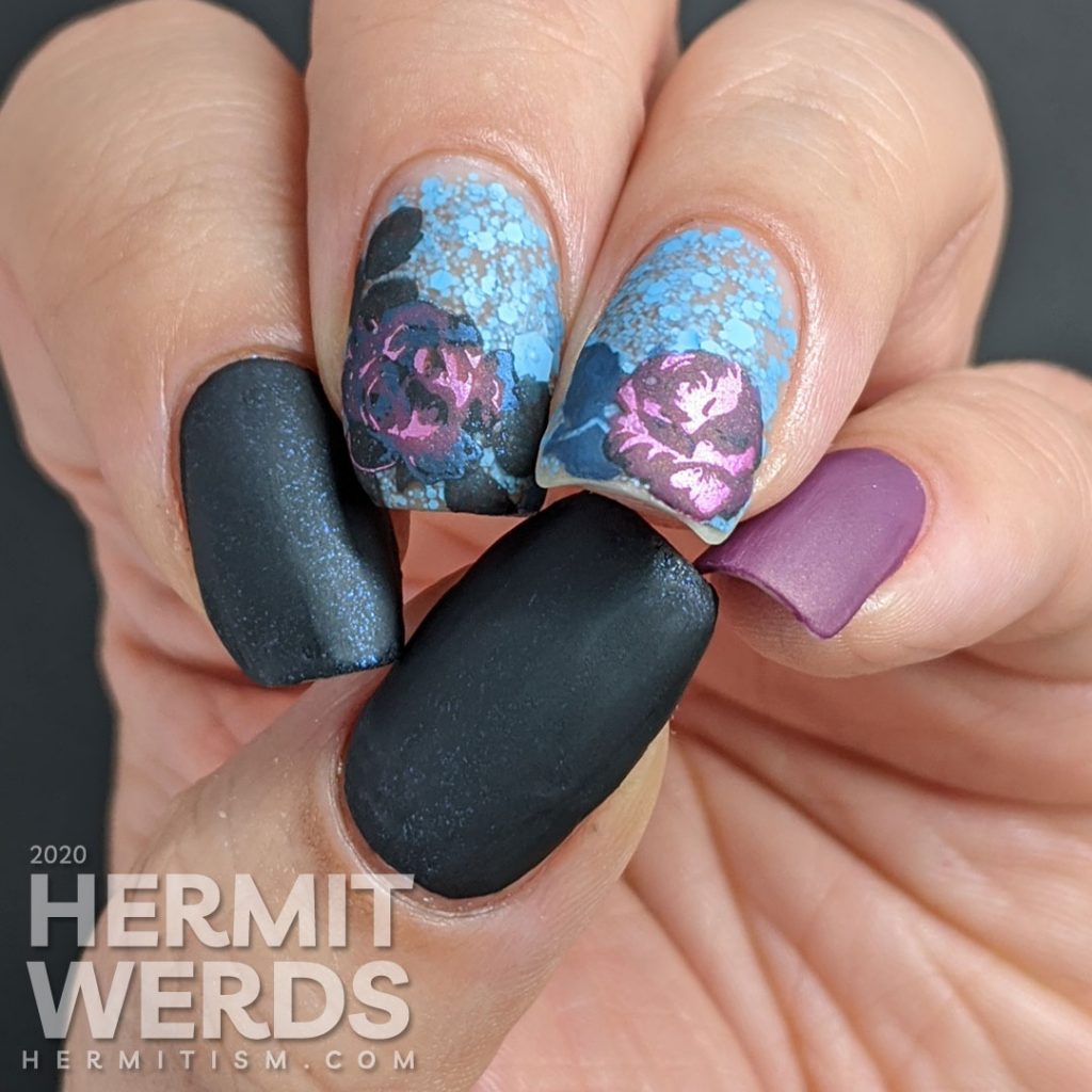 Purple and blue rose-themed nail art with layered stamping roses on a matte blue glitter background.