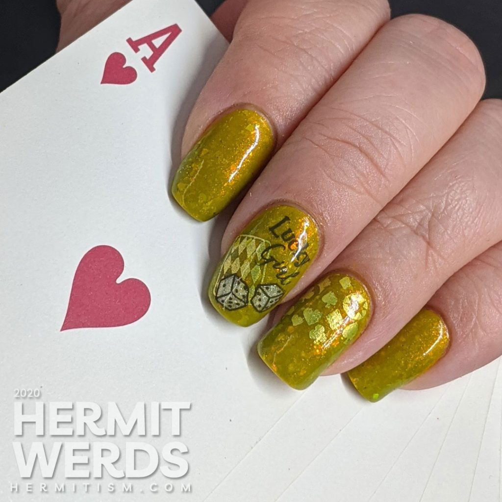 A medium olive/chartreuse nail art with luck, playing cards, dice, and heart/club/spade/diamond stamping decals.