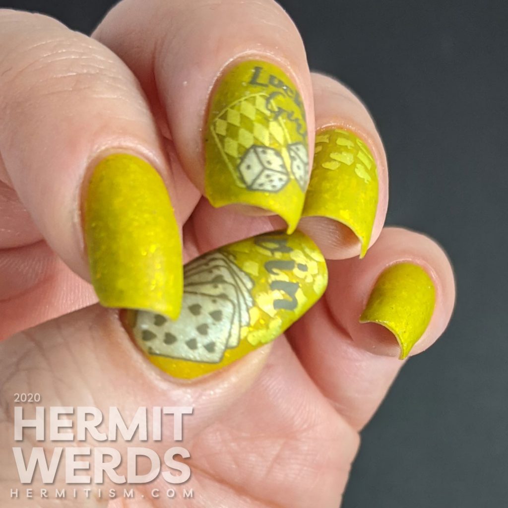 A medium olive/chartreuse nail art with luck, playing cards, dice, and heart/club/spade/diamond stamping decals.