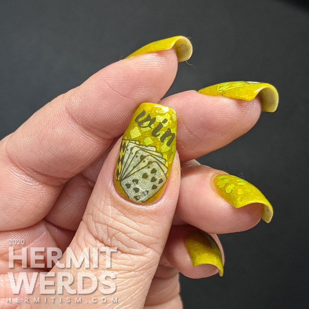 A medium olive/chartreuse nail art with luck, playing cards, dice, and heart/club/spade/diamond stamping decals.