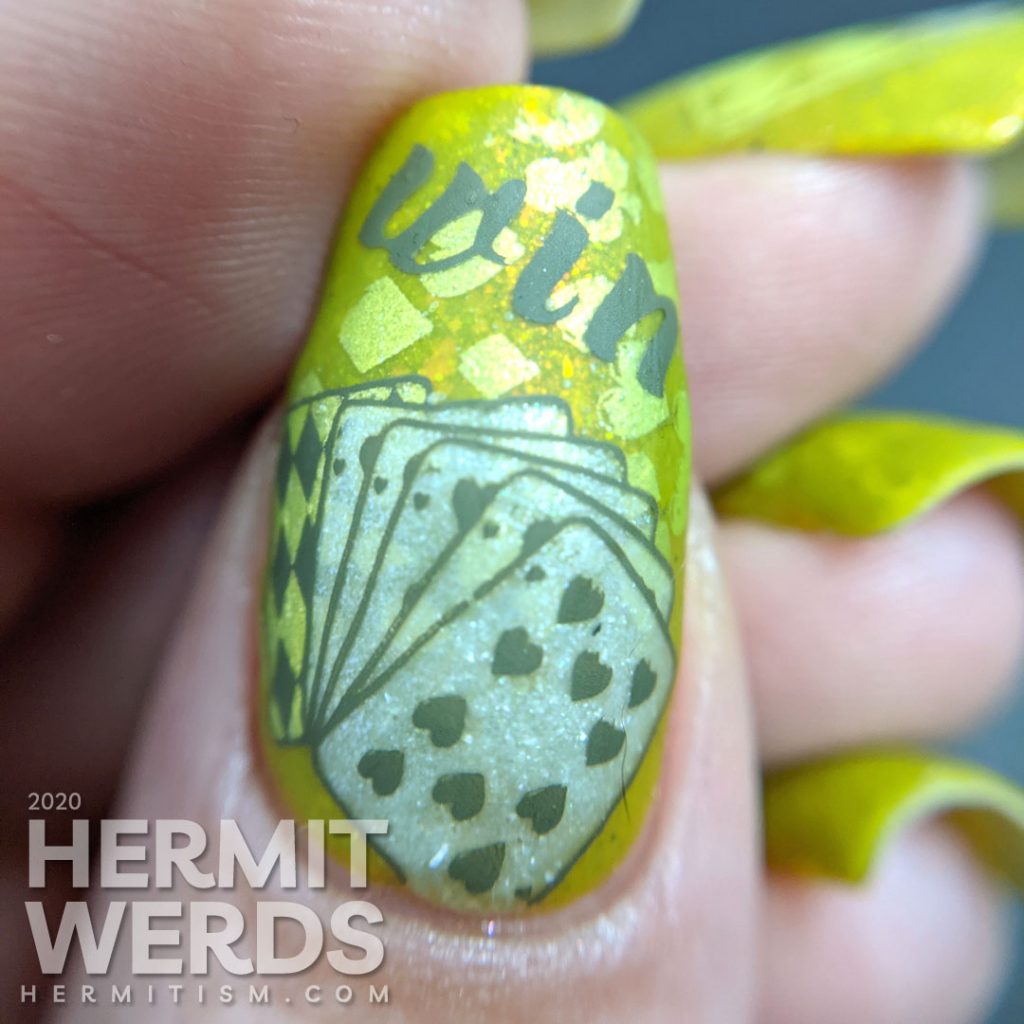 A medium olive/chartreuse nail art with luck, playing cards, dice, and heart/club/spade/diamond stamping decals.