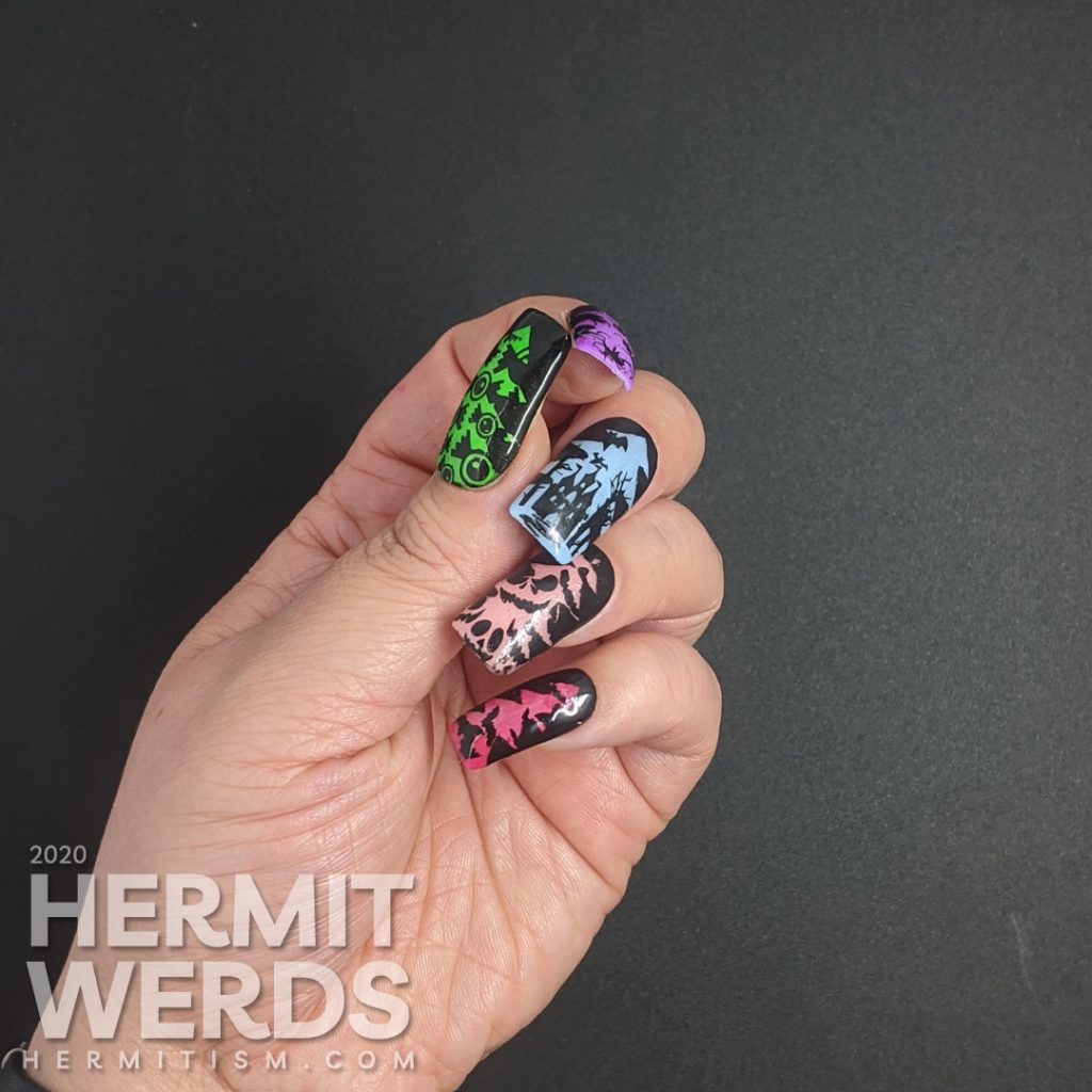 A rainbow glow in the dark mani of silhouetted Halloween images of bats, jack-o-lanterns, haunted castle, spiders, and eyeball candy glowing out from a Christmas tree frame.