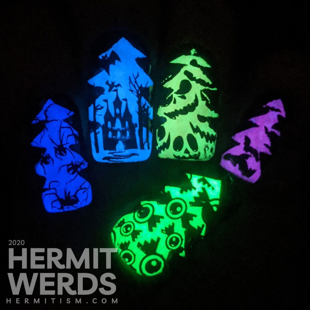 A rainbow glow in the dark mani of silhouetted Halloween images of bats, jack-o-lanterns, haunted castle, spiders, and eyeball candy glowing out from a Christmas tree frame.