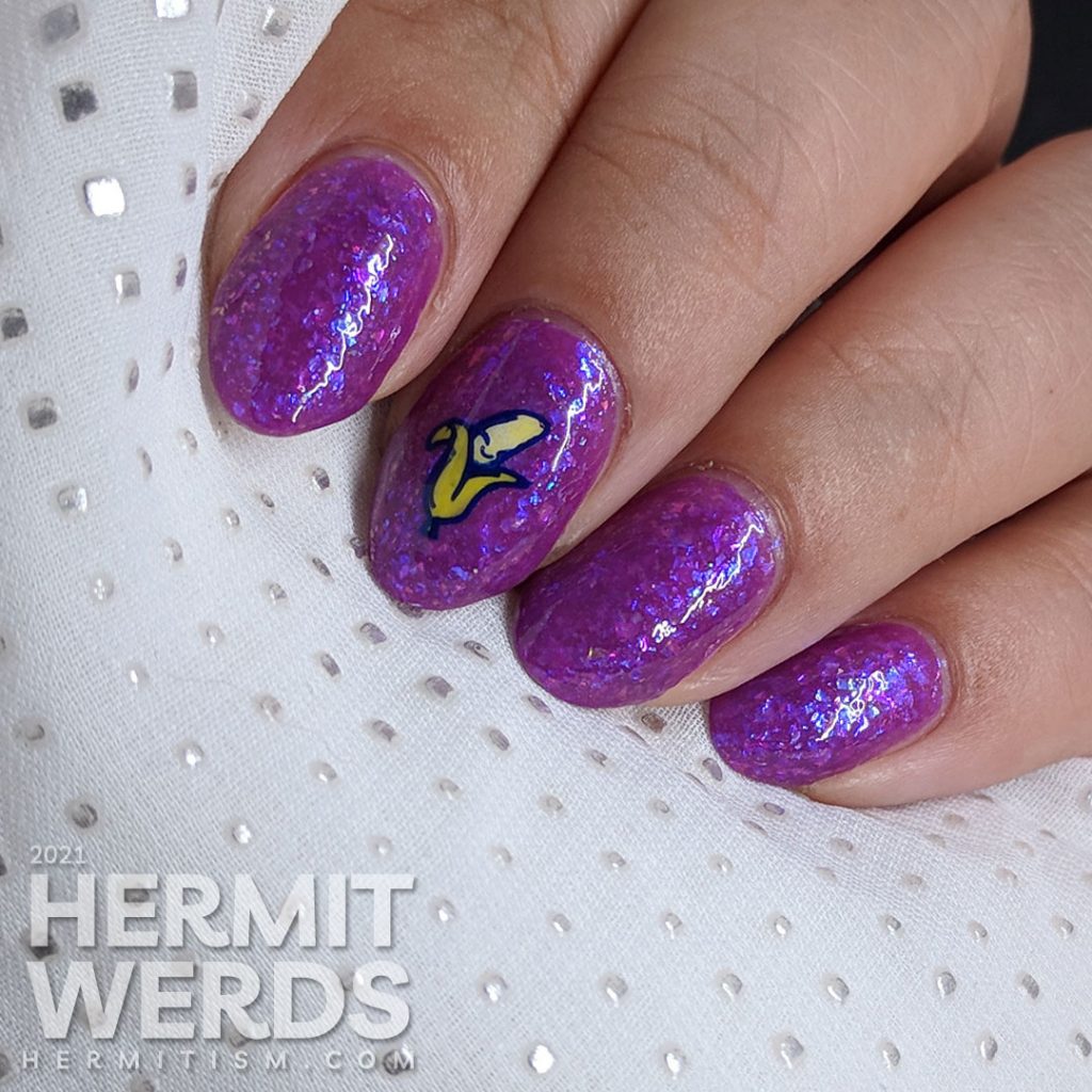 A magenta-purple mani with tons of blue and magenta flakies with a wee little smiling banana stamping decal.