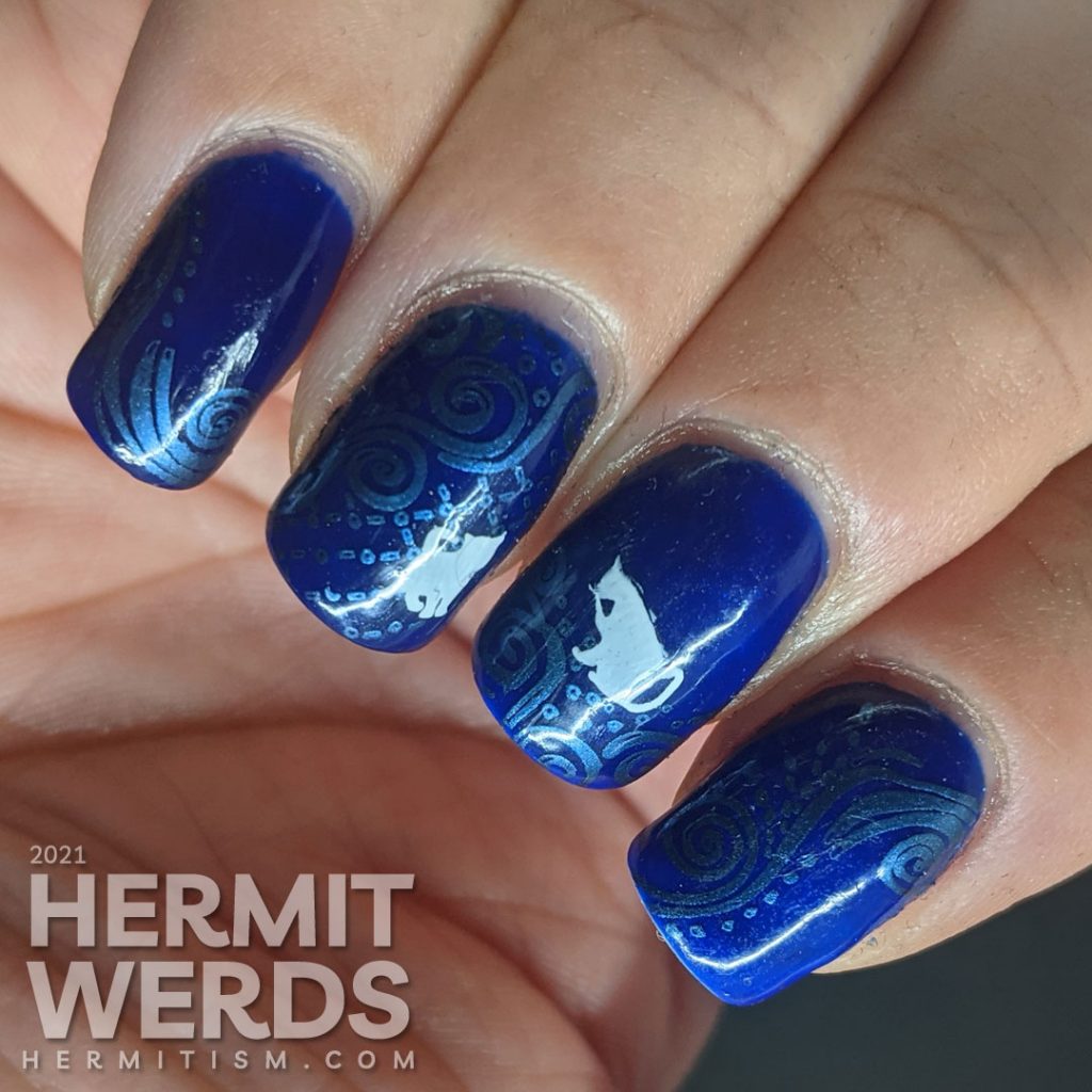 A dark blue nail art with metallic blue decorative swirls stamped in the background and little white cat silhouette stamping decals.