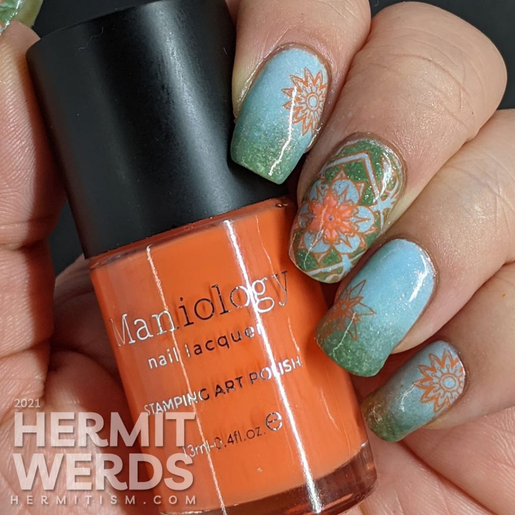 A pastel wintery nail art with snowflake-like flower stamping decals in green, aqua, and orange.