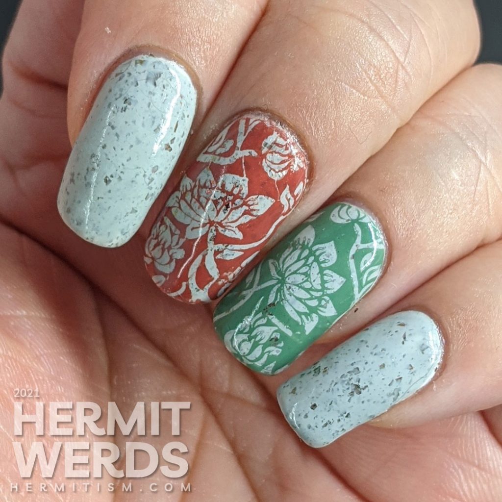 A grey crelly with flakies that shift from red, orange, gold, yellow and green with floral negative space stamps in red and green.