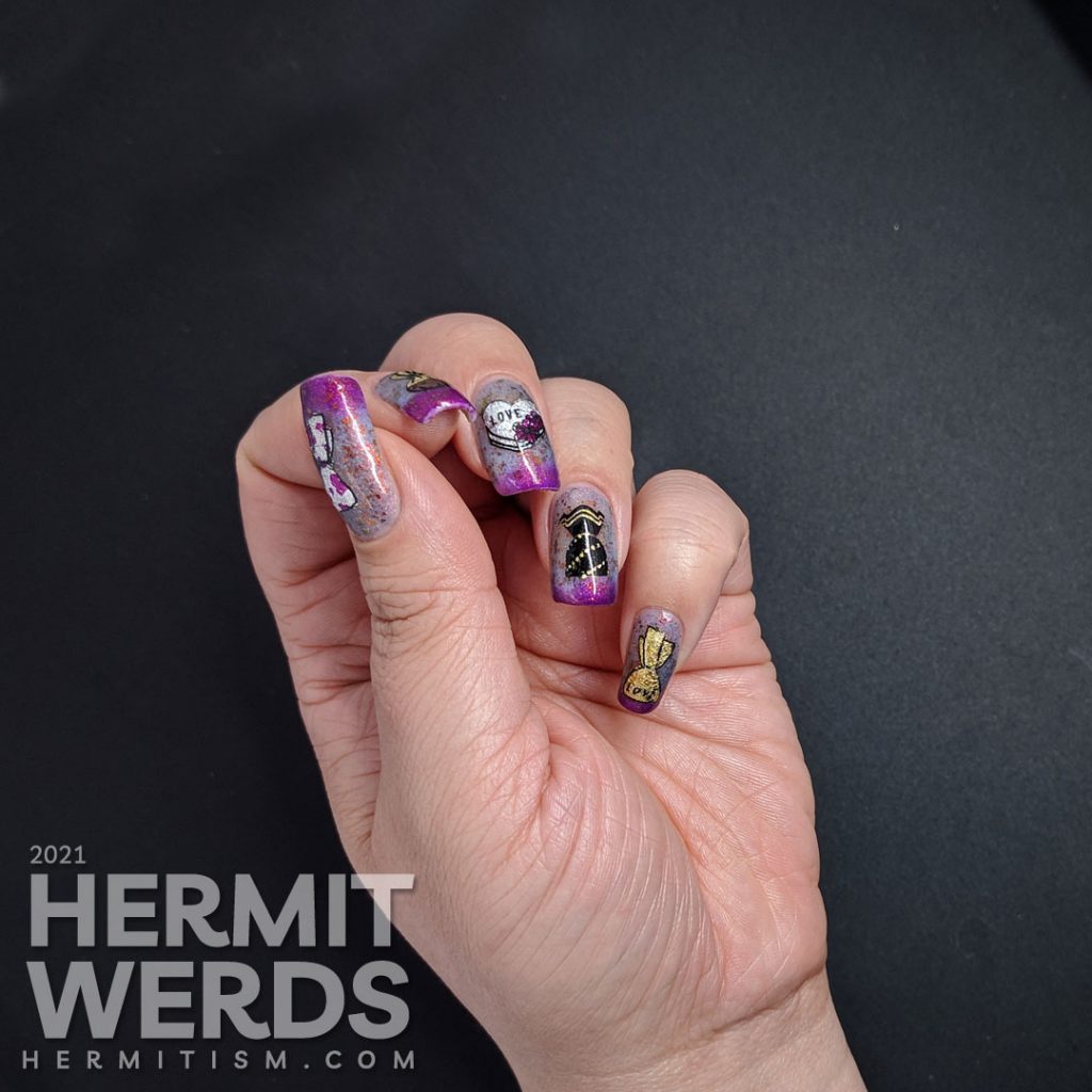 A Valentine's Day candy nail art with nail foil-filled candy stamping decals all on a dusty blue to magenta thermal polish with red to copper flakies.