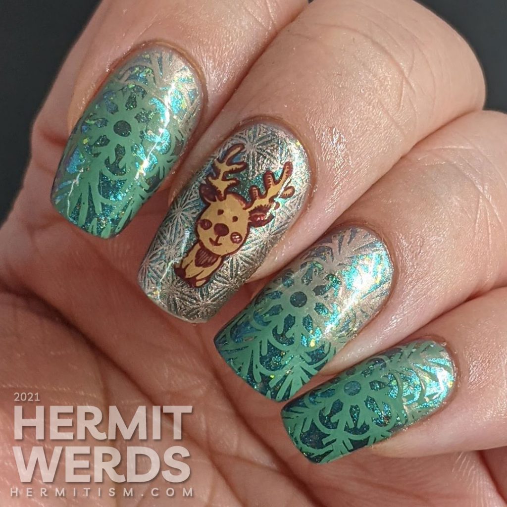 An aqua magnetic baby boomer french tip nail design with green to rose gold gradient snowflakes and a cute reindeer stamping decal.