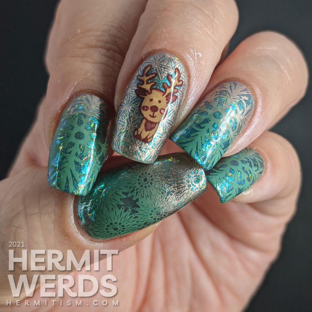 An aqua magnetic baby boomer french tip nail design with green to rose gold gradient snowflakes and a cute reindeer stamping decal.