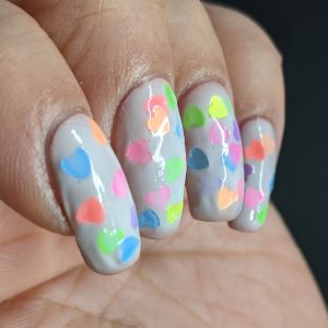 A white jelly pond mani with a neon rainbow of fluorescent heart sequins. Glow-y black light photos included.