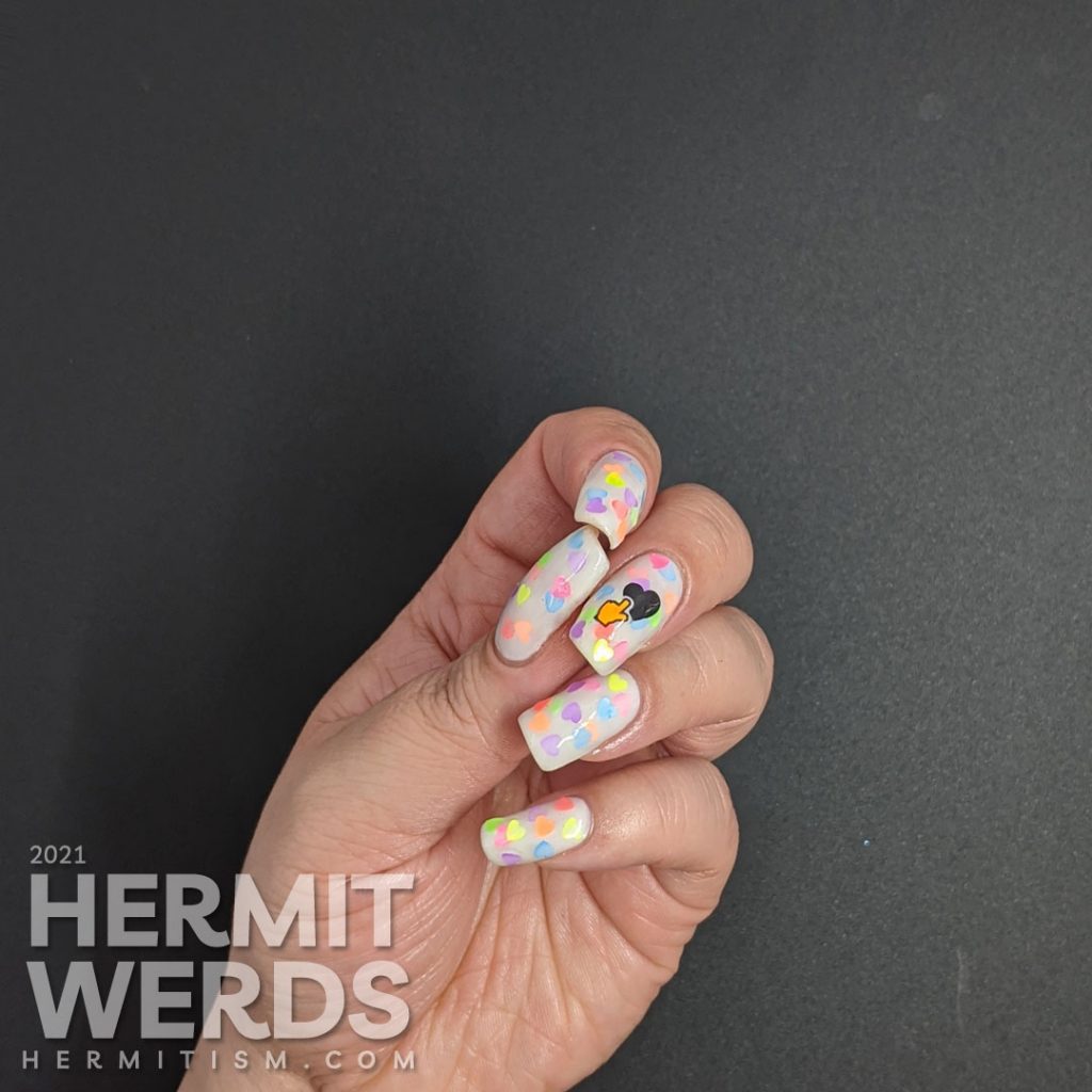 A white jelly pond mani with a neon rainbow of fluorescent heart sequins. Glow-y black light photos included.