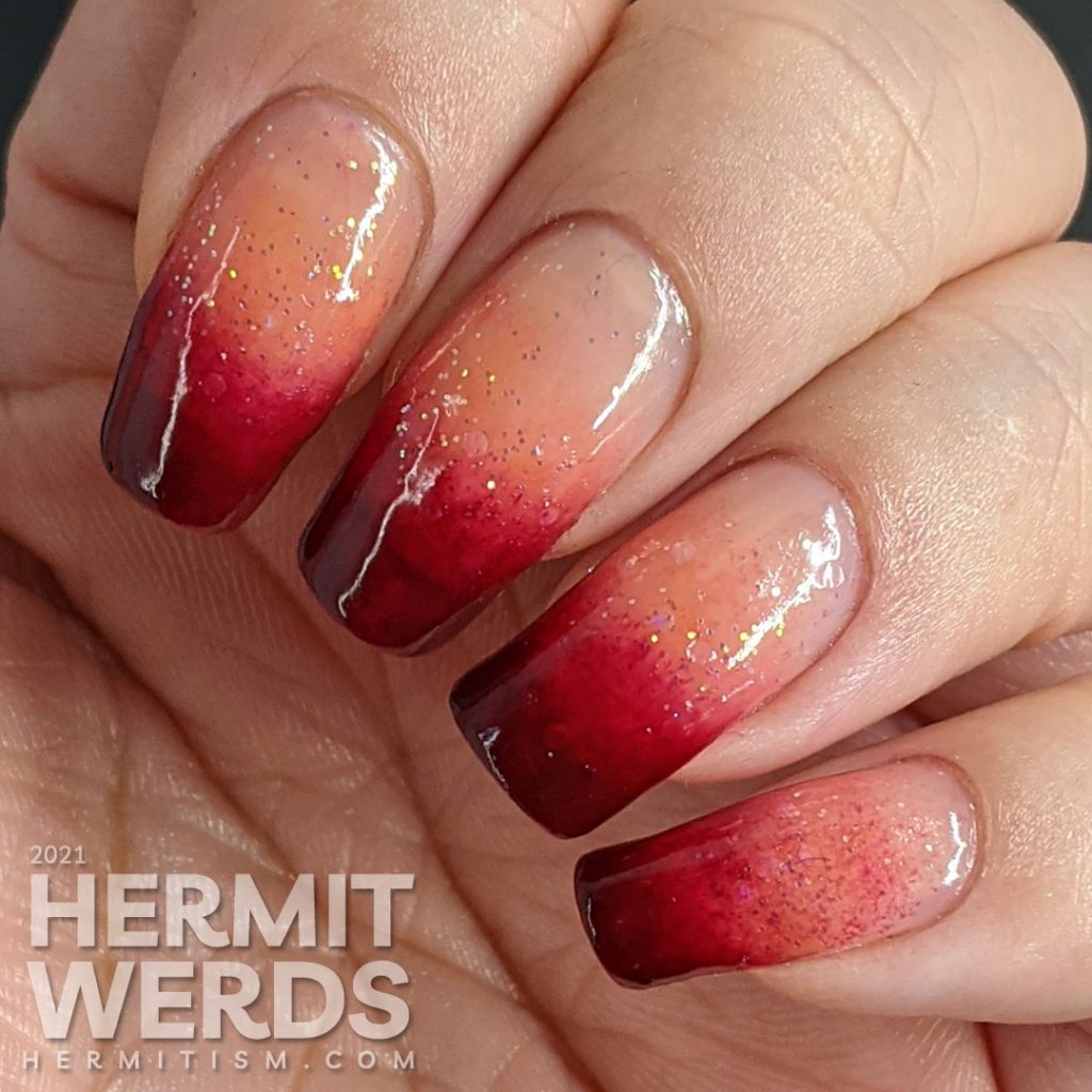 A dark burgundy to nude with glitter baby boomer French tip nail art.