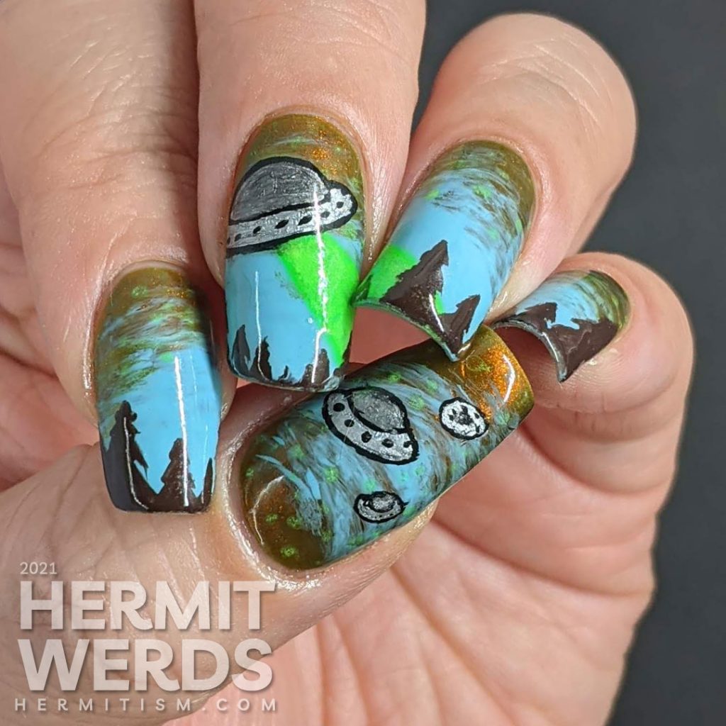 A freehand UFO nail art design with an multichrome olive/red and blue sky, silver UFO with glow in the dark tractor beam and stars.