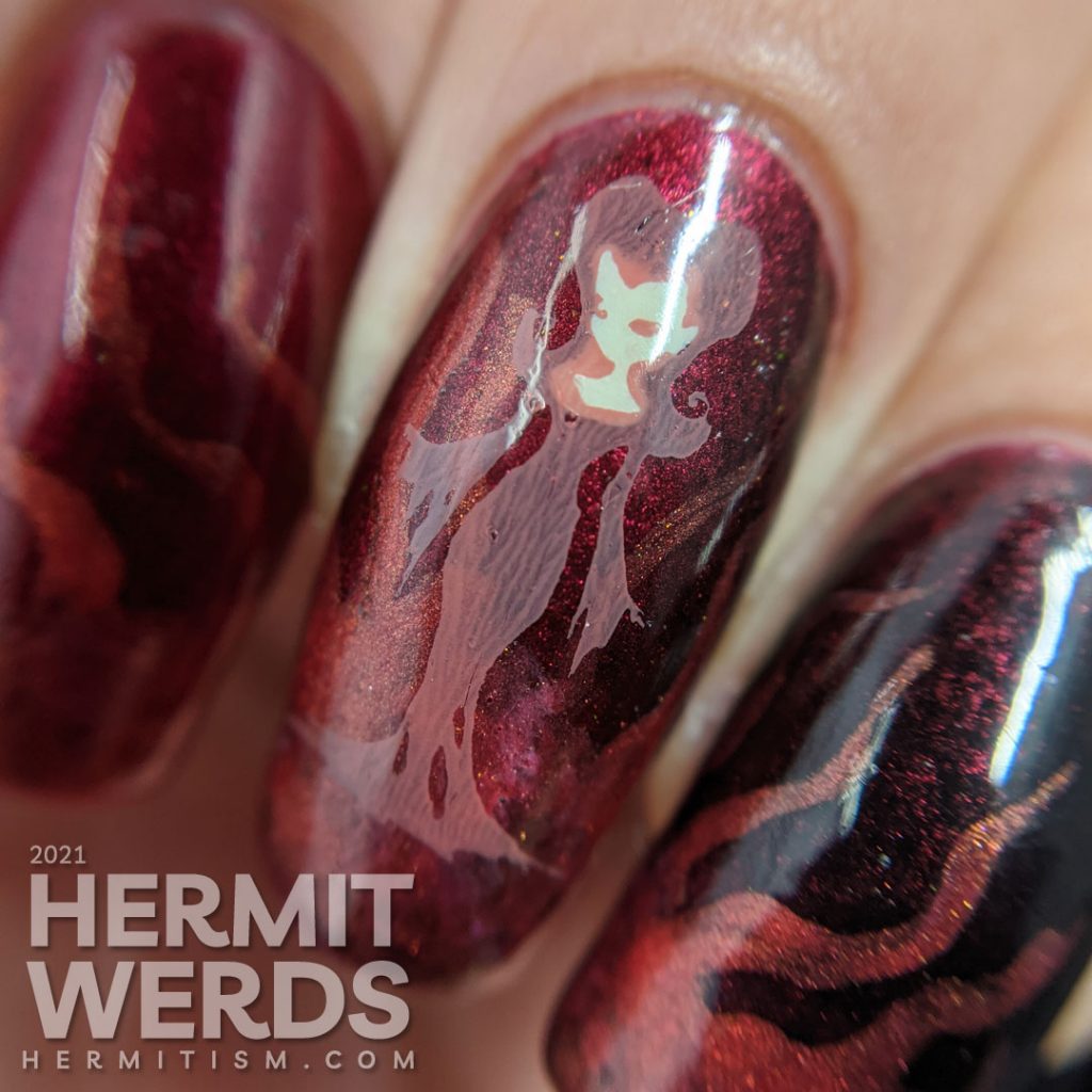 A red to black gradient nail art with swirls of magic and a wicked, sexy witch casting a summoning stamped on top plus a haunted house.