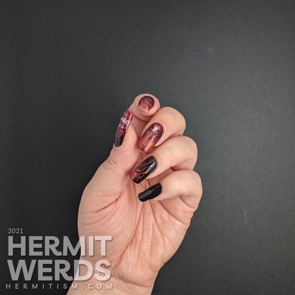 A red to black gradient nail art with swirls of magic and a wicked, sexy witch casting a summoning stamped on top plus a haunted house.