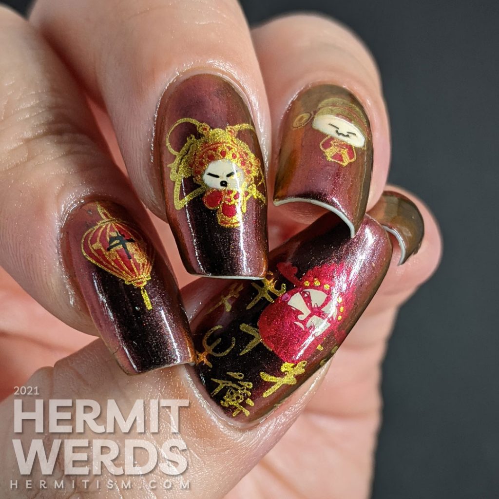 Year of the Ox nail art on a black/red/gold multichrome base with chibi Chinese opera performers, lanterns, and ox symbols.