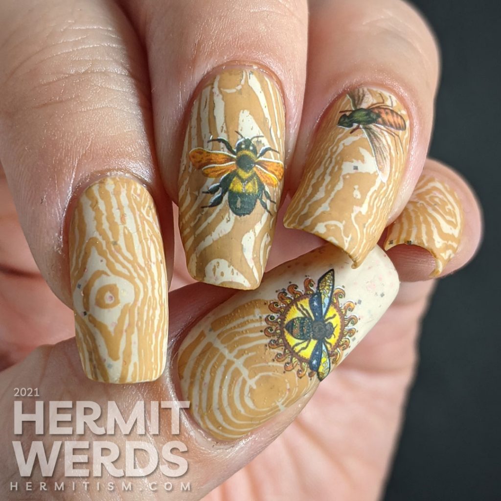 A soft tan and caramel wood texture nail art with bright water decal bugs on top.