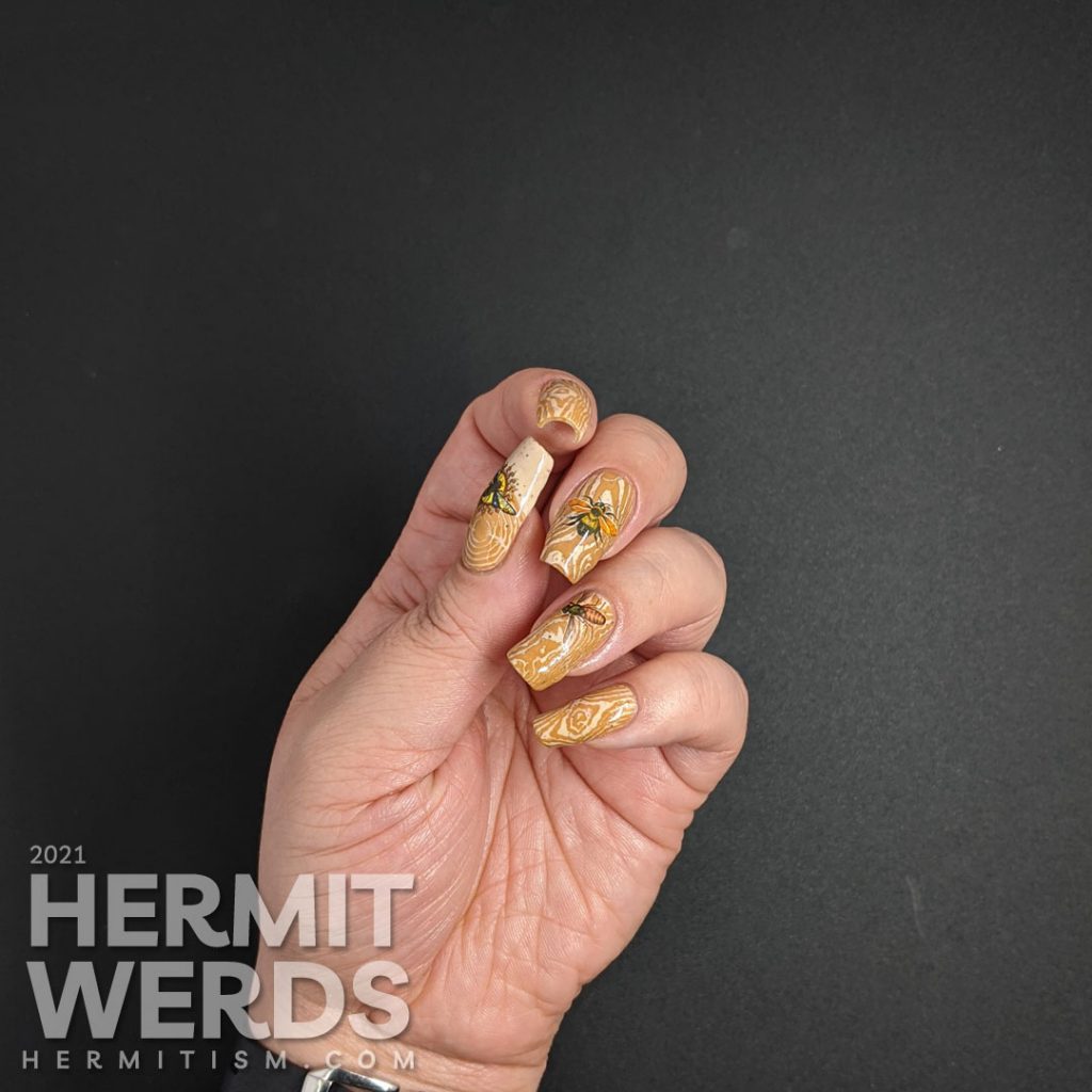 A soft tan and caramel wood texture nail art with bright water decal bugs on top.