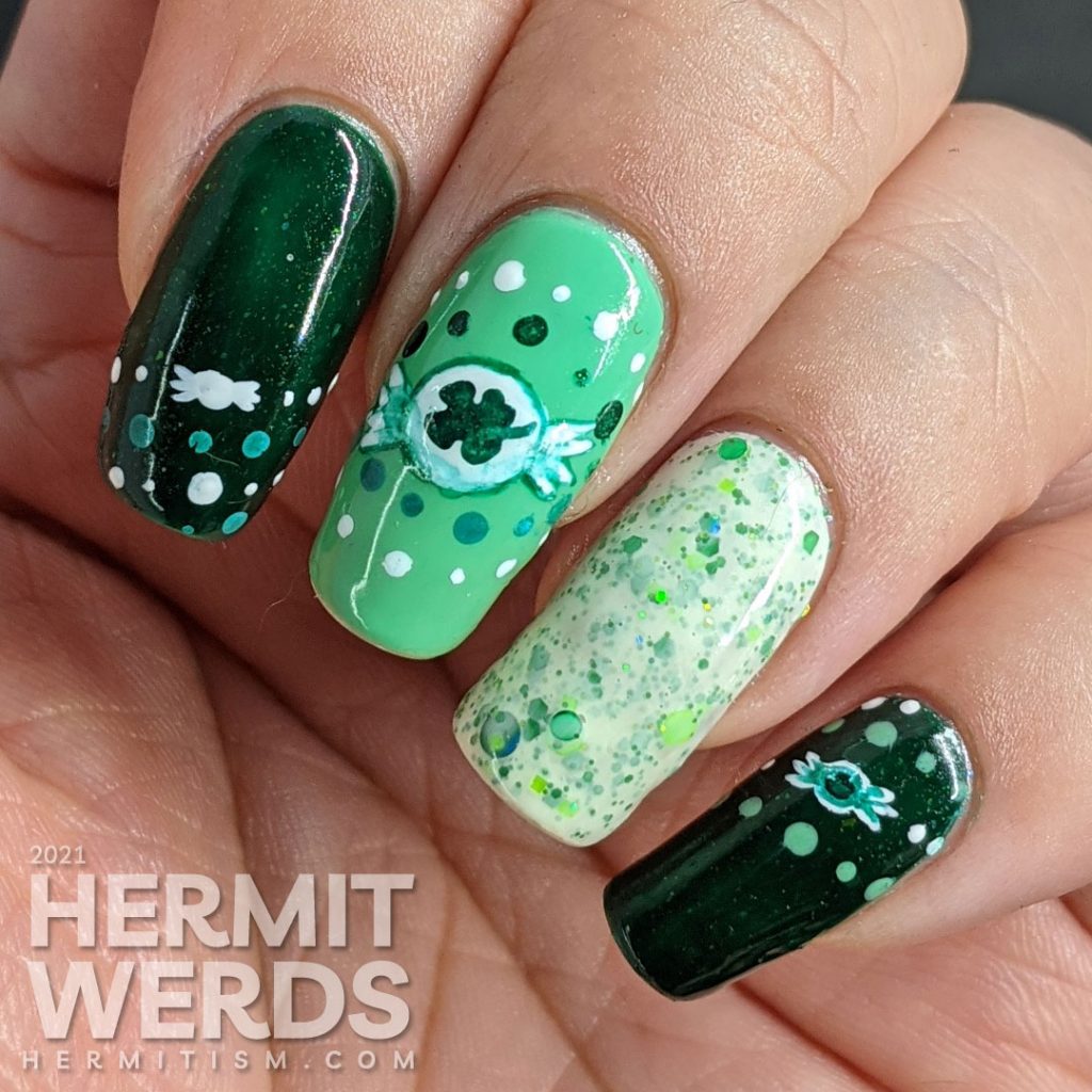 A dotticure clover candy nail art with freehand painted clover hard candies and polka dot patterns.