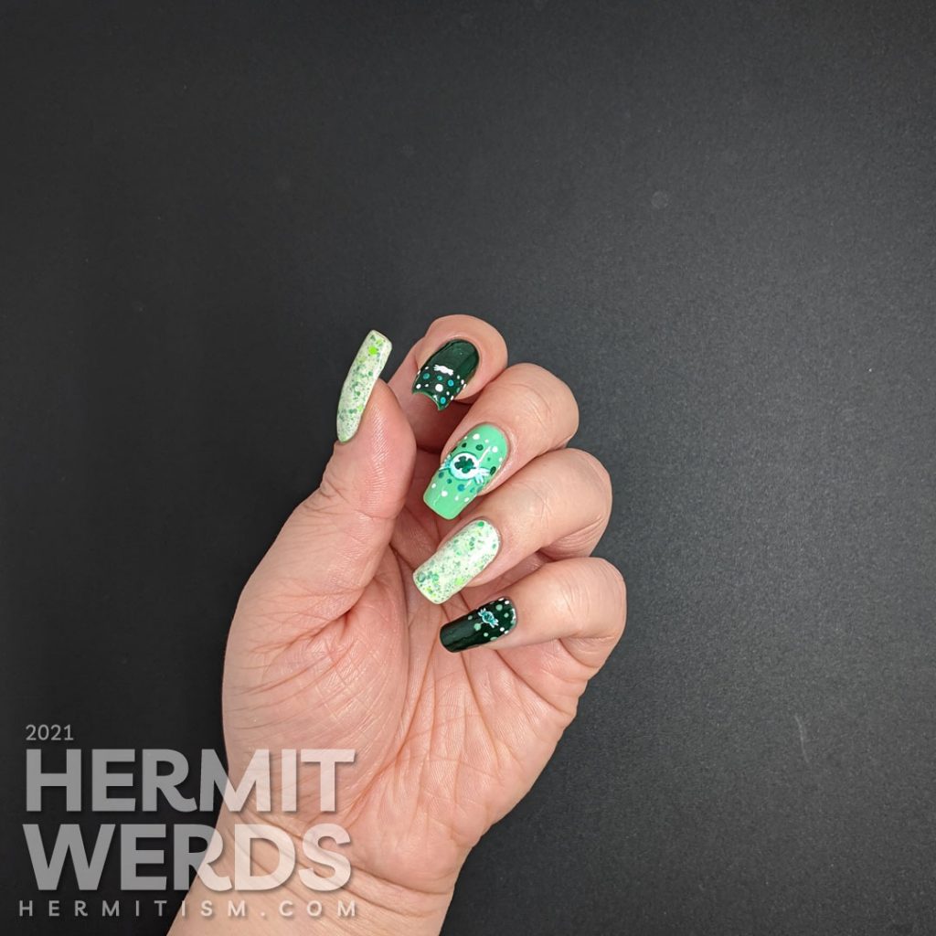 A dotticure clover candy nail art with freehand painted clover hard candies and polka dot patterns.