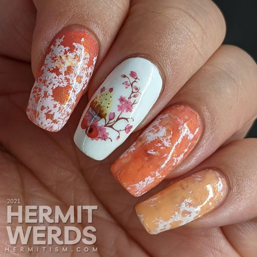 A cupcake nail art with a cupcake water decal accent nail and creamsicle-like water spotted nails in white, orange, and coral.