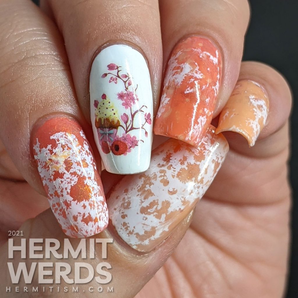 A cupcake nail art with a cupcake water decal accent nail and creamsicle-like water spotted nails in white, orange, and coral.