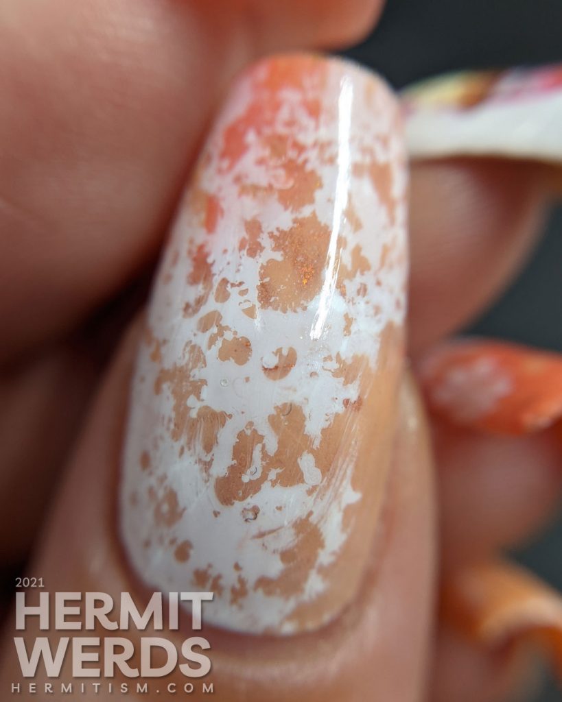 A cupcake nail art with a cupcake water decal accent nail and creamsicle-like water spotted nails in white, orange, and coral.