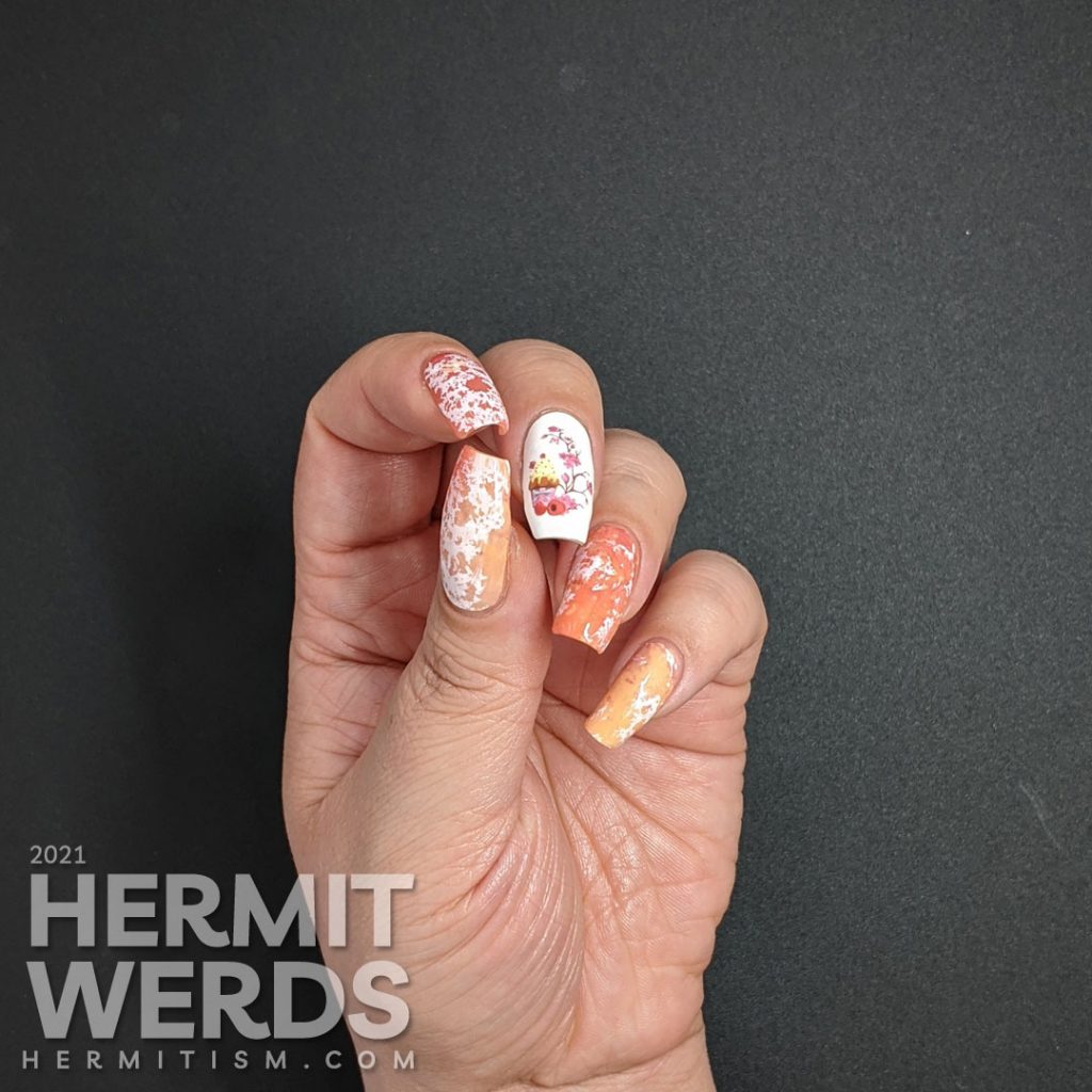 A cupcake nail art with a cupcake water decal accent nail and creamsicle-like water spotted nails in white, orange, and coral.