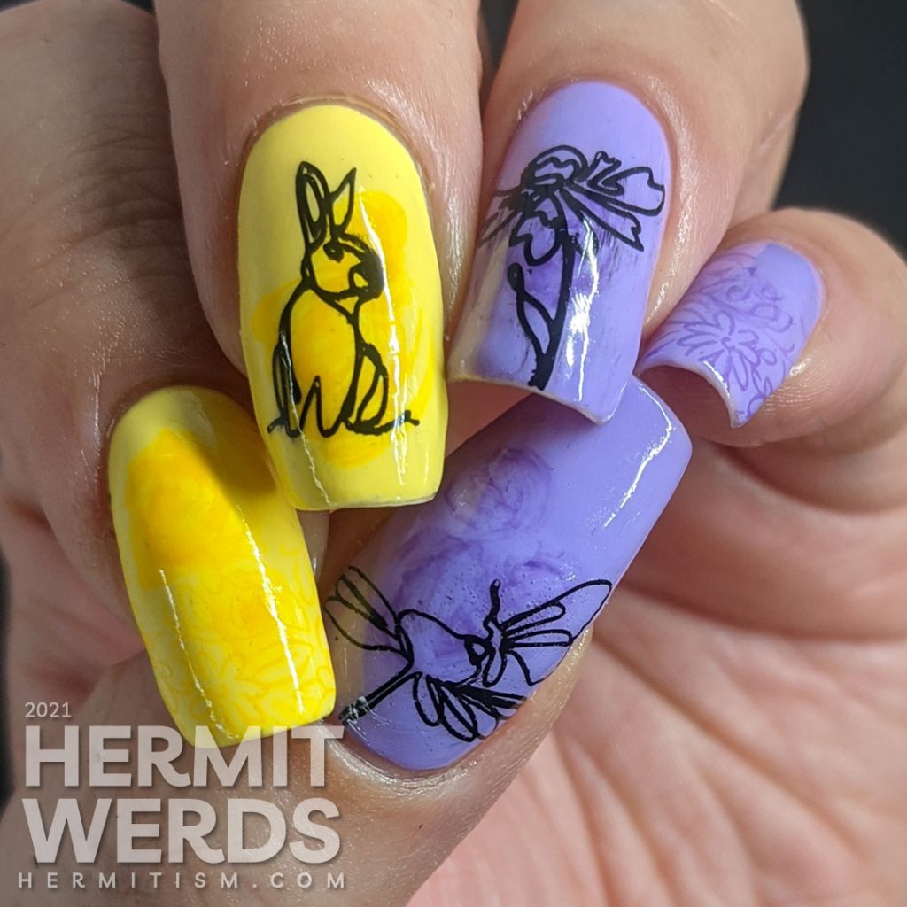Light purple and yellow nail art with swirls of darker polish highlighting freeline spring images of a bunny and flowers.
