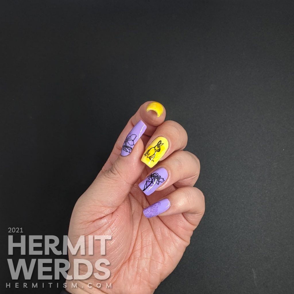 Light purple and yellow nail art with swirls of darker polish highlighting freeline spring images of a bunny and flowers.
