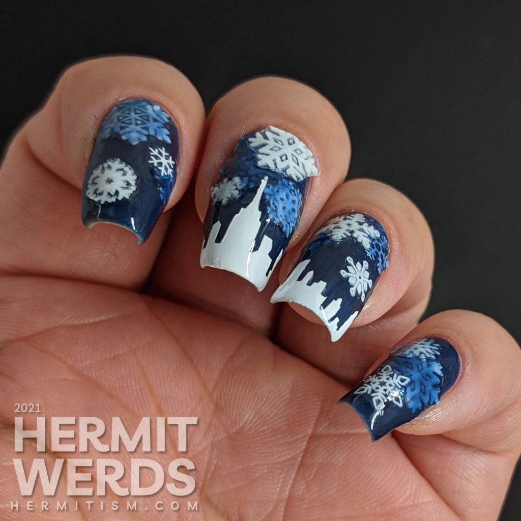 A pond mani with glow in the dark snowflake stickers and a white panoramic cityscape using a dark blue jelly polish.
