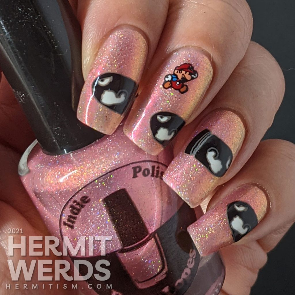 A pink to gold multichrome with holographic nail art featuring Nintendo's Mario dodging multiple Bullet Bills.