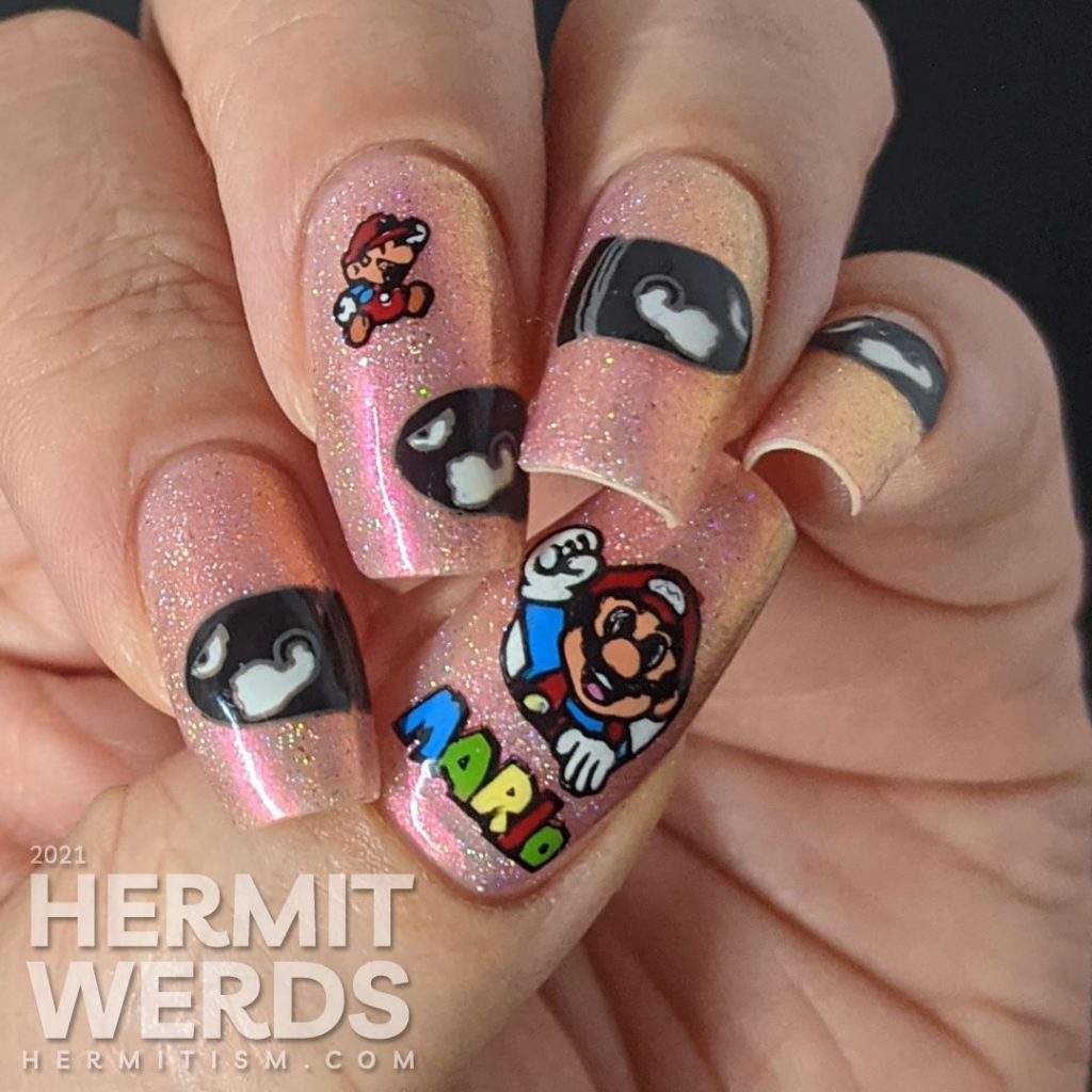 A pink to gold multichrome with holographic nail art featuring Nintendo's Mario dodging multiple Bullet Bills.