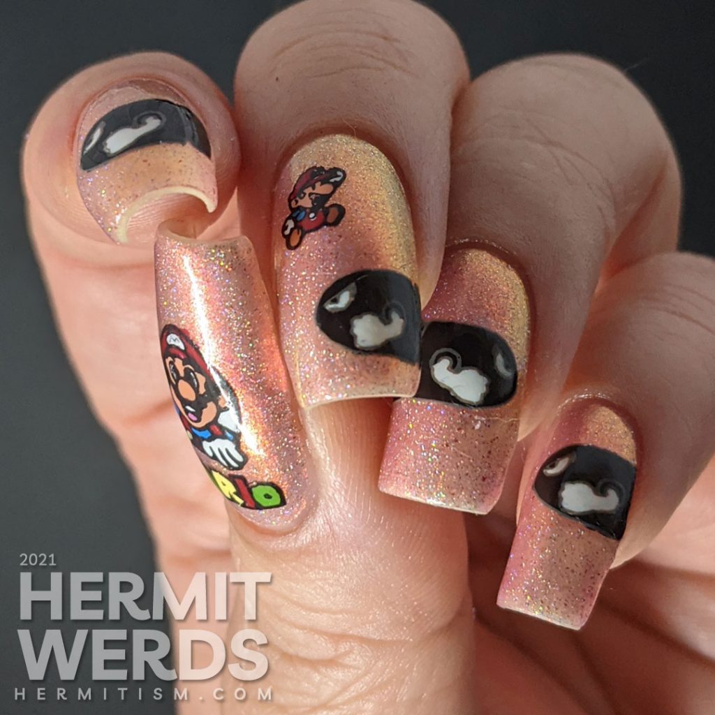 A pink to gold multichrome with holographic nail art featuring Nintendo's Mario dodging multiple Bullet Bills.