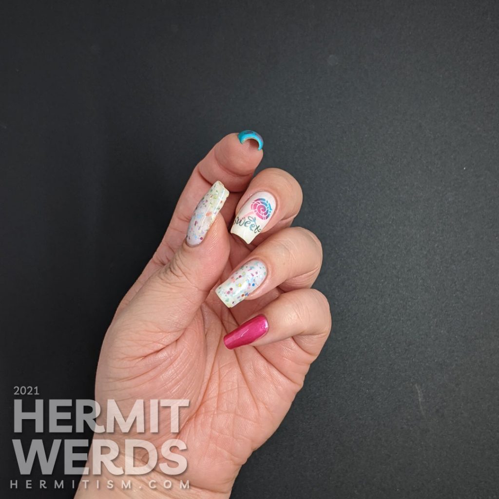 Cute candy nail art in blue, pink, and white with lollipop stamping decals, the word "sweet", and a rainbow crelly.