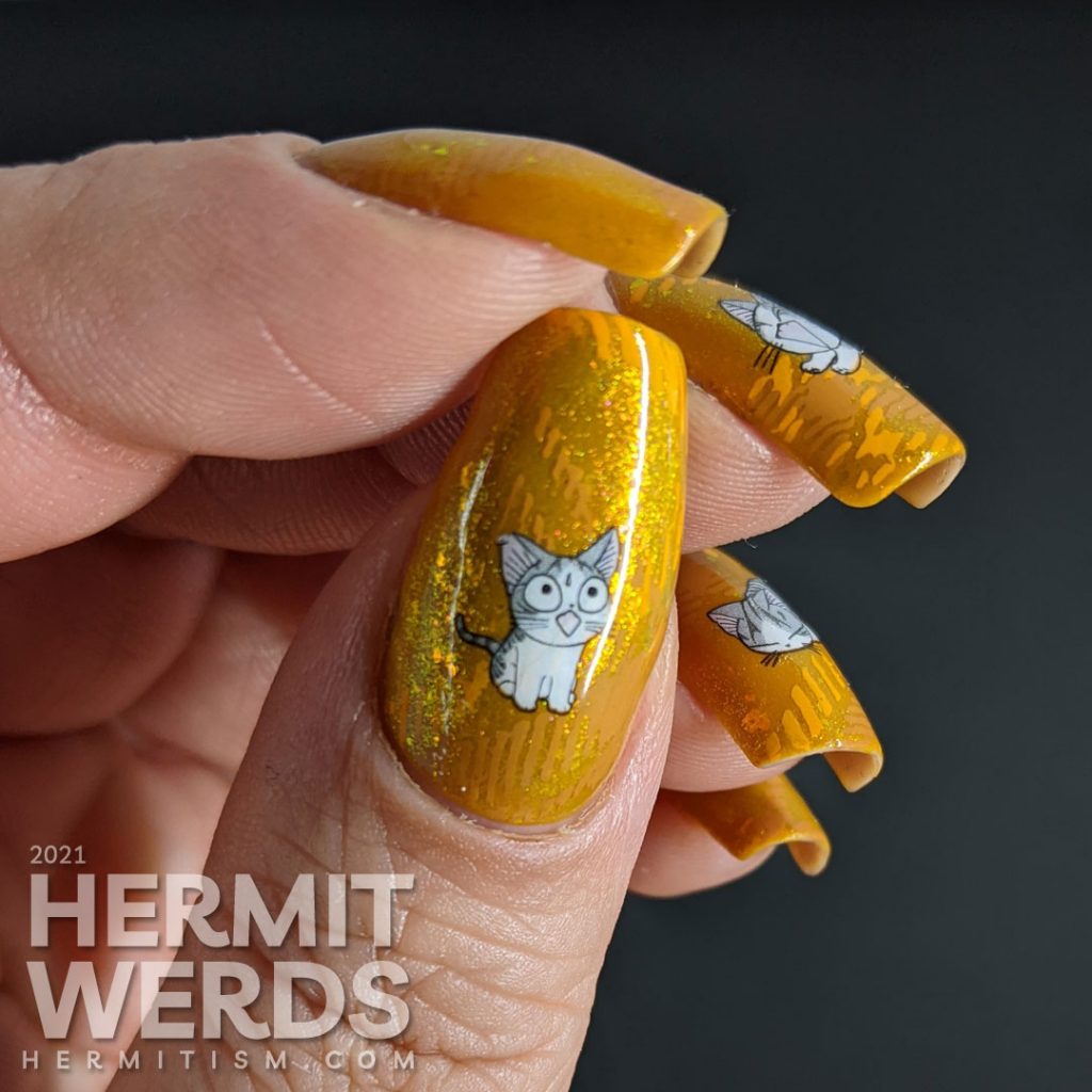 A super mustard-y nail art with a stamped plaid background pattern and cute grey cat water decals sleeping, playing, and talking to you.