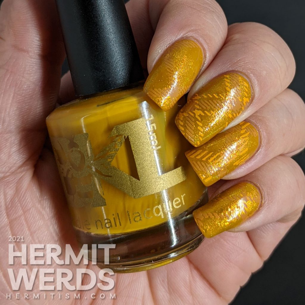 A super mustard-y nail art with a stamped plaid background pattern.