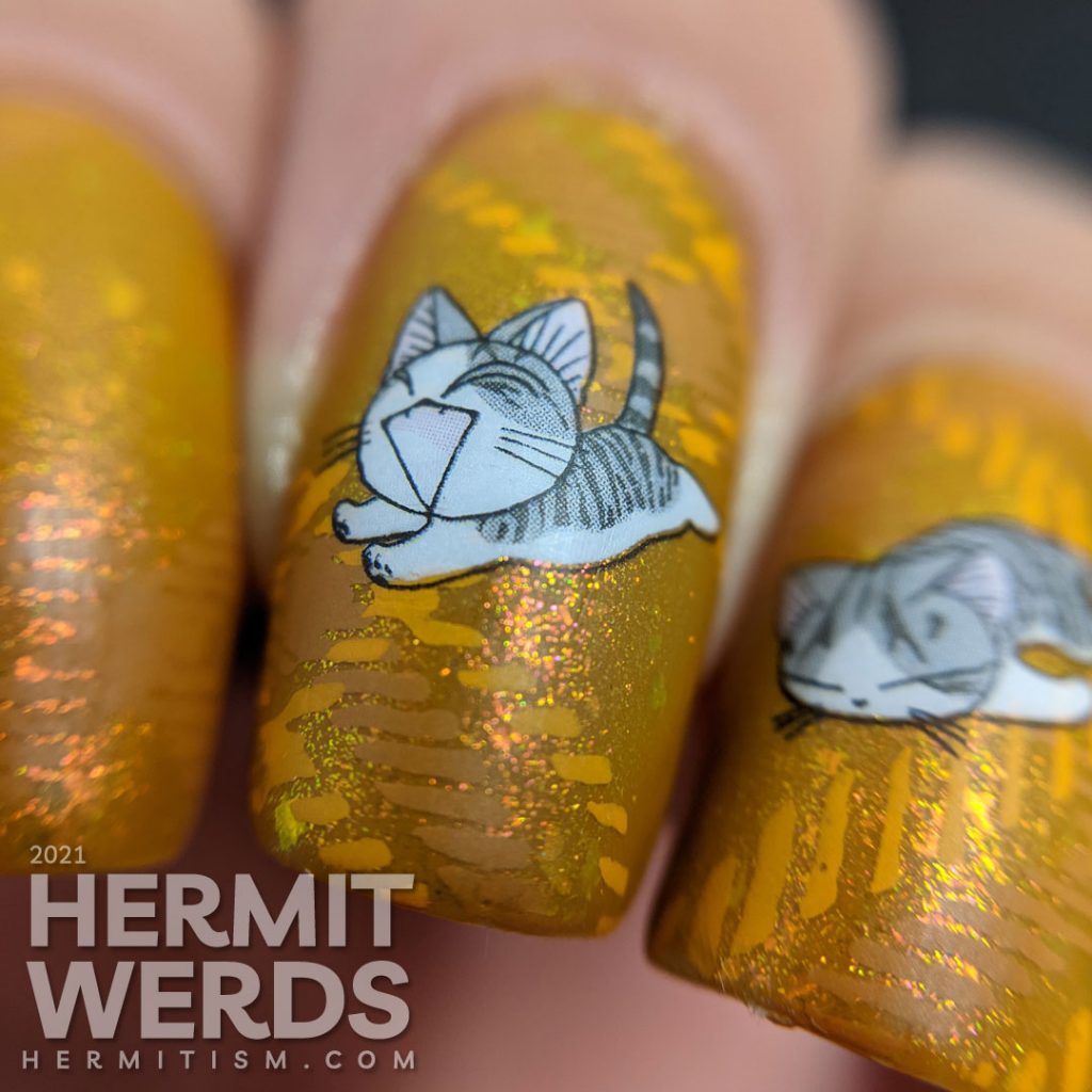 A super mustard-y nail art with a stamped plaid background pattern and cute grey cat water decals sleeping, playing, and talking to you.