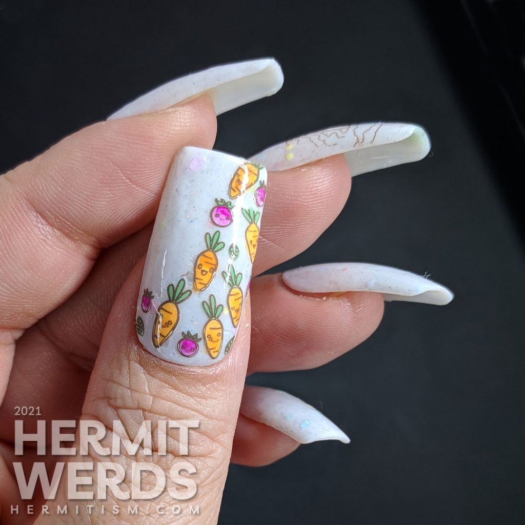 Easter nail art starting with a soft grey crelly with pastel glitters and a cute anthropomorphic bunny wearing a carrot t-shirt and carrots!