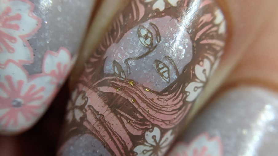 A soft grey nail art with stamping decals of sakura blossom French tips a pink-haired woman with more flowers and a blooming cherry tree.