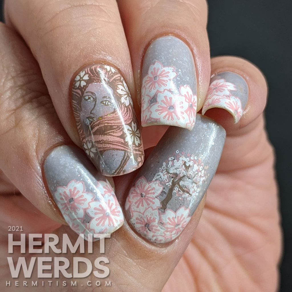 A soft grey nail art with stamping decals of sakura blossom French tips a pink-haired woman with more flowers and a blooming cherry tree.