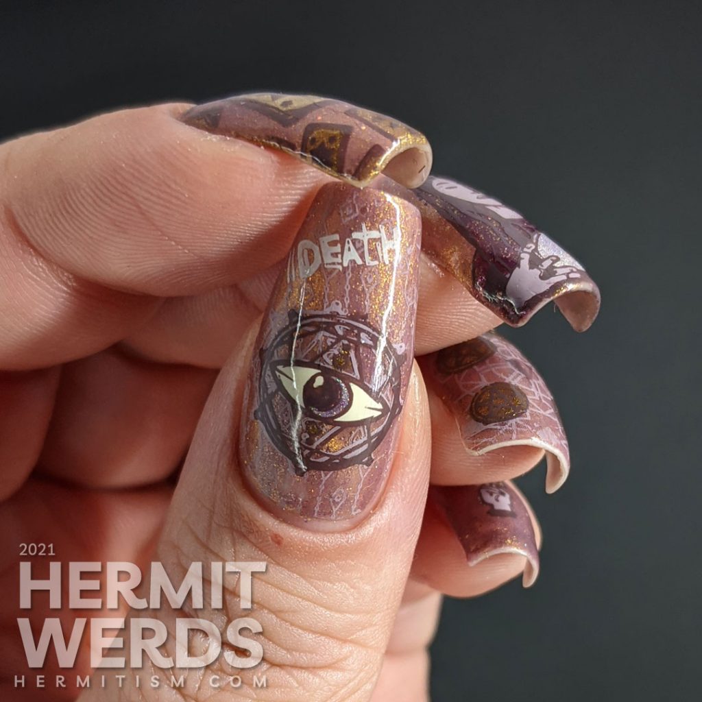 A mauve and gold magnetic nail art with tarot cards, the five of pentacles, all-seeing eye, and a fortune teller and her crystal ball.