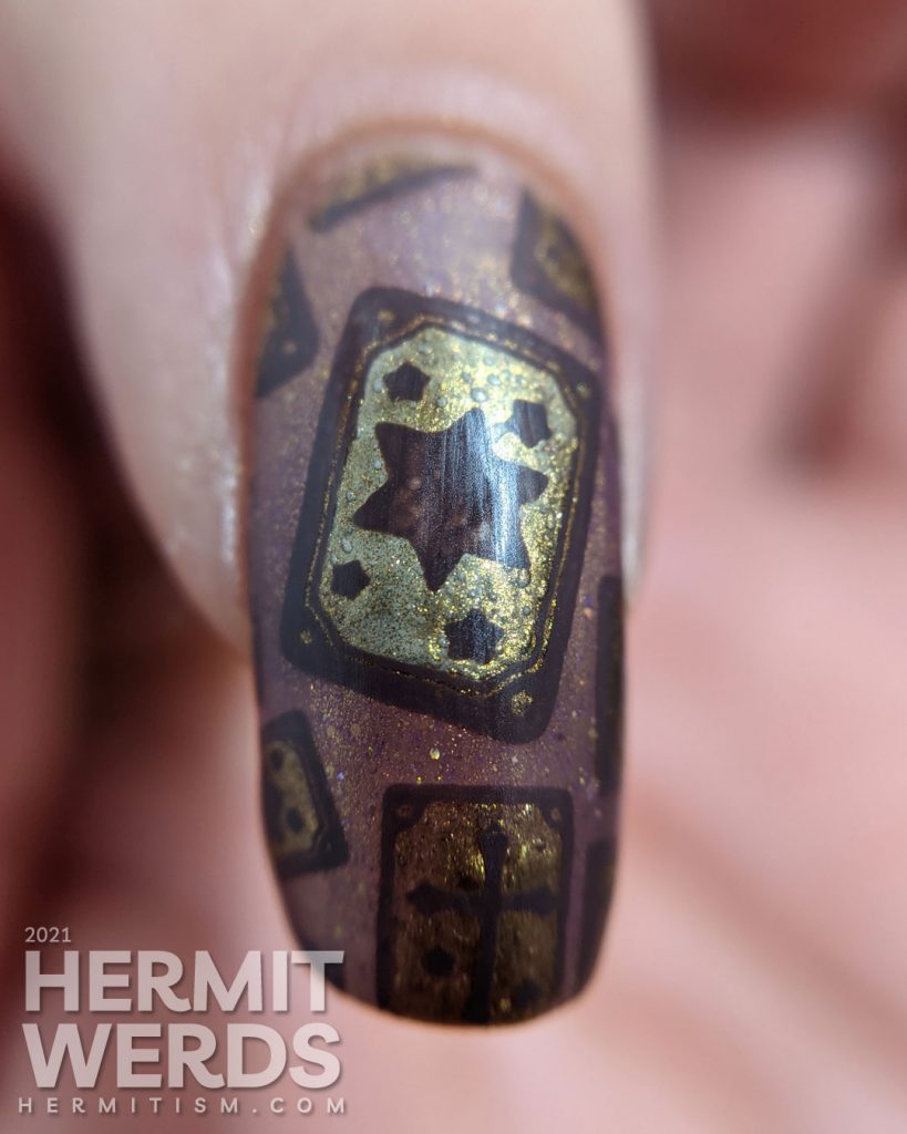 A mauve and gold magnetic nail art with tarot cards, the five of pentacles, all-seeing eye, and a fortune teller and her crystal ball.
