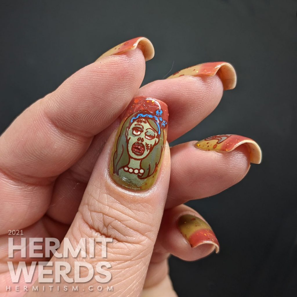 Zombie nail art with cartoon zombie head stamping decals and on a mustard/orange/brown tri-thermal base with orange and gold glitters.