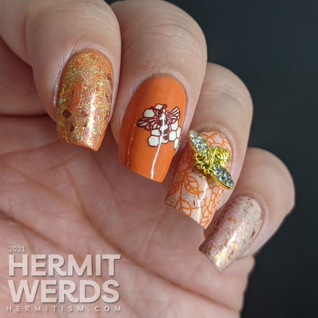 An orange and light pink mani with a super flakie rose gold topper, gold bee nail charm, and simple bee mosaic stamping decals.